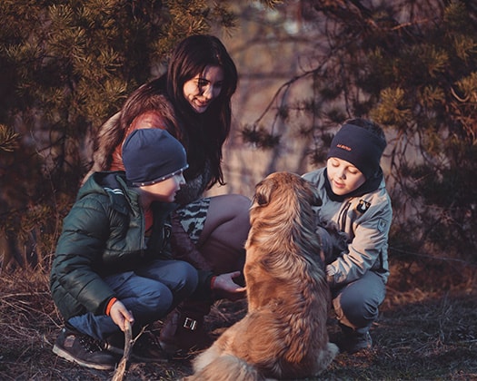 Familie mit Hund unter dem Motto: Jede Hunderasse birgt ihren ganz eigenen Charakter.